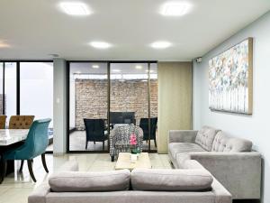 un soggiorno con un divano e un tavolo di Piscina con Bbq en Villa privada cerca de centros comerciales con 3 habitaciones, 5 Camas, seguridad 24-7 a Bellavista