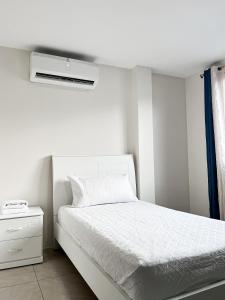 una camera bianca con letto e condizionatore d'aria di Piscina con Bbq en Villa privada cerca de centros comerciales con 3 habitaciones, 5 Camas, seguridad 24-7 a Bellavista Altre 62 foto