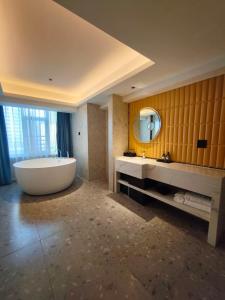 Meisu Huanman Hotel Changsha IFS Wuyi Square Branch في تشانغشا: حمام كبير مع حوض كبير ومرآة