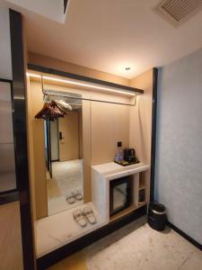 Meisu Huanman Hotel Changsha IFS Wuyi Square Branch في تشانغشا: غرفة بها مرآة وغرفة بها أحذية