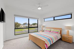 een slaapkamer met een bed en een groot raam bij Mercer on Port in Portarlington