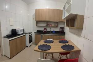 a kitchen with a wooden table with chairs and a stove at Casa 3km da praia com piscina, 3 quartos, 2 km das praia do Aracagir in São Luís +4 photos