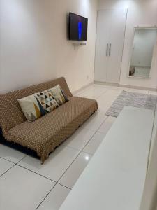 a living room with a couch and a tv at refugio pe na areia in Rio de Janeiro