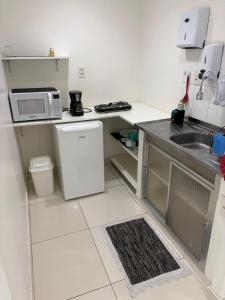 a small kitchen with a sink and a refrigerator at refugio pe na areia in Rio de Janeiro