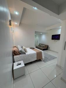 a bedroom with a bed and a tv on a wall at refugio pe na areia in Rio de Janeiro