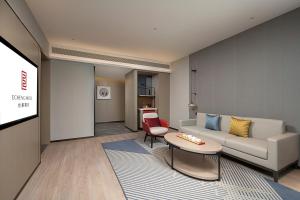 a living room with a couch and a table at Hefei High-Speed Railway South Station North Square Yicheng Hotel in Hefei