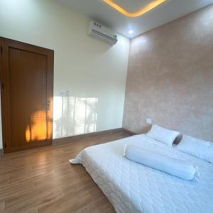 a bedroom with a large white bed with white sheets at Shin's House Cozy & Green Space in Phu Quoc