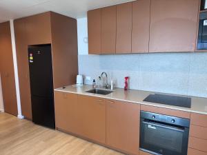 a kitchen with brown cabinets and a sink and a refrigerator at South Melbourne retreat in Melbourne +8 photos