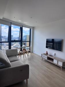 a living room with a couch and a tv and a table at South Melbourne retreat in Melbourne