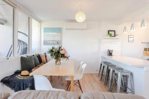 een keuken en woonkamer met een tafel en stoelen bij Aldinga Beach Breakaway - C21 SouthCoast Holidays in Aldinga Beach +34 foto's