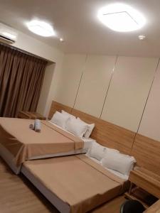 a hotel room with two beds and a mirror at Luntian Luxury Condo in Tagaytay in Iruhin