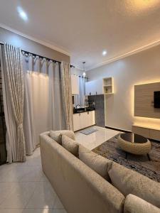 坎帕拉Dee furnished homes Kyanja的客厅里有一张沙发和一个厨房