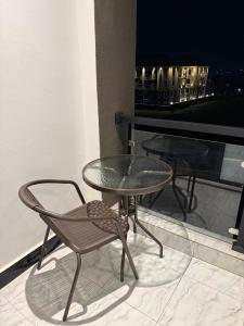 坎帕拉Dee furnished homes Kyanja的阳台上的玻璃桌和椅子