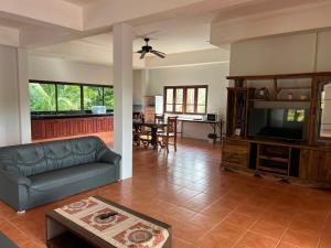 a living room with a couch and a tv at Theorenda house in Ban Taling Ngam