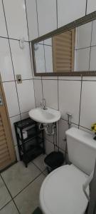 a bathroom with a white toilet and a sink at Fique a vontade in Uberaba