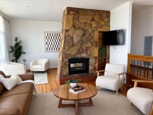 a living room with a large stone fireplace at Simple Comfort: Bridport Retreat in Bridport