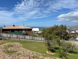 a house with a fence in front of a yard at Simple Comfort: Bridport Retreat in Bridport