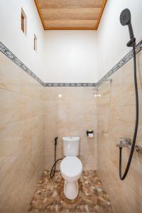 ein Badezimmer mit Toilette und Dusche in der Unterkunft Puspa Guest House Lembongan in Nusa Lembongan