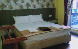 a bed with two towels on it in a room at Casa D'rose Hotel in Malacca