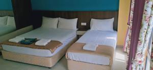 two twin beds in a hotel room with towels at Casa D'rose Hotel in Malacca