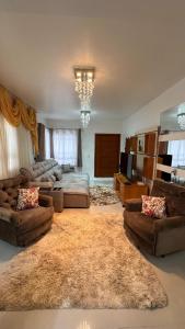 Una gran sala de estar con sofás y una alfombra grande. en Casa c Piscina Gigante, Lareira e Churrasqueira, en Campo Bom