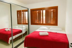1 dormitorio con 2 camas con sábanas rojas y espejo en Casa c Piscina Gigante, Lareira e Churrasqueira, en Campo Bom 17 fotos más