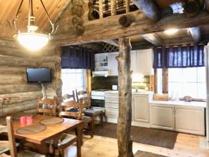 una cucina e una sala da pranzo con tavolo in una cabina di Villa Kelotupa a Hossa