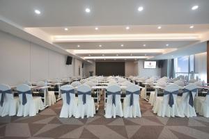 a conference room with tables and chairs and a screen at Hefei High-Speed Railway South Station North Square Yicheng Hotel in Hefei