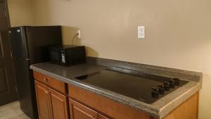 een keuken met een fornuis en een magnetron naast een koelkast bij Gated - 2 Double Bed Studio with Full Kitchen 110 in Baton Rouge
