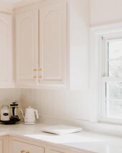 een aanrecht met witte kasten en een raam bij Waterfront Cottage Getaway Views, Kayaks, Fire Pit 