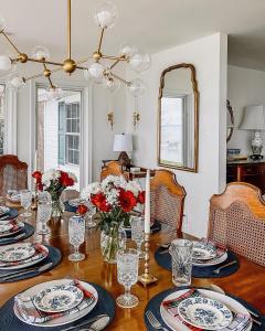 een eetkamer met een tafel met rode bloemen erop bij Waterfront Cottage Getaway Views, Kayaks, Fire Pit 