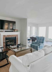 een woonkamer met een bank en een open haard bij Waterfront Cottage Getaway Views, Kayaks, Fire Pit 