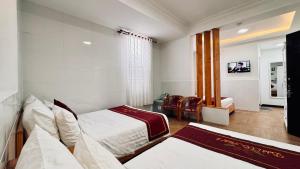 a hotel room with two beds and a television at Dalat ECO Hotel 2 in Da Lat