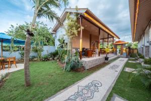ein Haus mit einem Garten mit einem Rasenplatz in der Unterkunft Puspa Guest House Lembongan in Nusa Lembongan