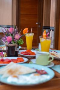 einen Holztisch mit Teller mit Speisen und Getränken in der Unterkunft Puspa Guest House Lembongan in Nusa Lembongan + 29 Fotos