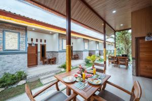 einen Essbereich mit einem Holztisch und Stühlen in der Unterkunft Puspa Guest House Lembongan in Nusa Lembongan