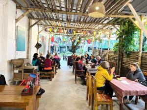 a group of people sitting at tables in a restaurant at Discovery Lodge Phong Nha in Cừ Lạc