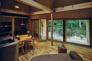a living room with a table and a large window at SANU 2nd Home Minami-Alps 1st in Wada