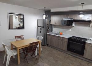 a kitchen with a wooden table and a dining room at Encantador y equipado en el corazón de la CDMX in Mexico City