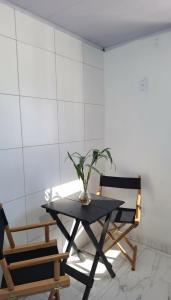 uma mesa com uma planta ao lado de duas cadeiras em Casa da Angela Quarto Triplo no Rio de Janeiro