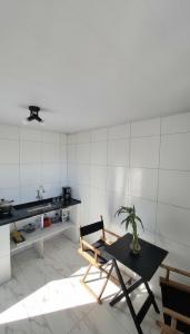 uma sala com mesa e cadeiras e uma cozinha em Casa da Angela Quarto Triplo no Rio de Janeiro