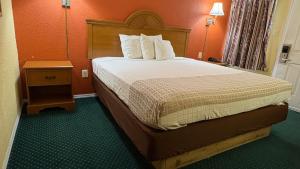 a hotel room with a bed and a night stand at Red Bank Inn in Leonards
