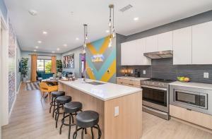 a kitchen with a counter and stools in it at Hyve - Neon Lights - Pool & Gym - Walk to Broadway in Nashville