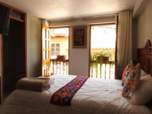 奥兰太坦波Rumi Wasi Inn Ollantaytambo的一间带大床的卧室，带窗户