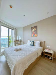 a bedroom with a large bed and a large window at căn hộ the sóng 3 phòng ngủ in Vung Tau +19 photos