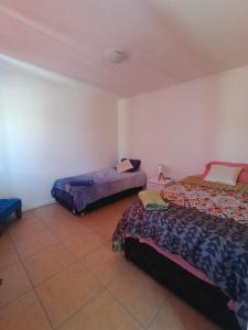 um quarto com 2 camas e piso em azulejo em Casa privada en condominio em Calama