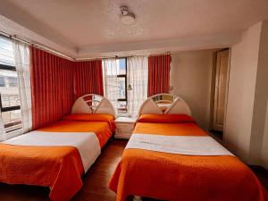 zwei Betten, die in einem Zimmer nebeneinander stehen in der Unterkunft Hotel Señorial in Ambato