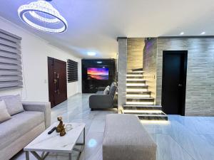un soggiorno con un divano e una scala di Villa con piscina privada y BBQ, 3 habitaciones, 5 camas, seguridad 24-7 a Amalia