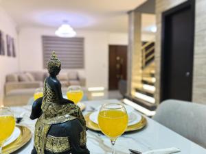 un tavolo con bicchieri da vino e una statua sopra di Villa con piscina privada y BBQ, 3 habitaciones, 5 camas, seguridad 24-7 a Amalia