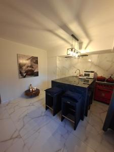 cocina con fregadero y encimera con taburetes en Departamento Vicco, en Pinamar